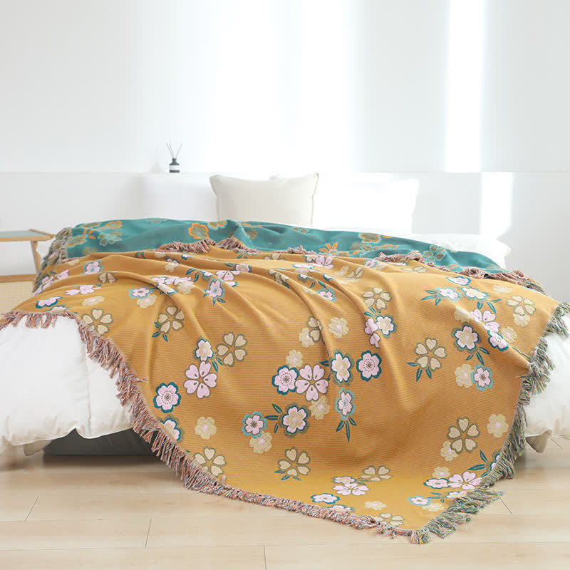 Weiche Decke mit Quasten und blühenden Blumen