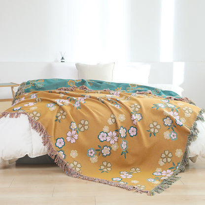 Weiche Decke mit Quasten und blühenden Blumen