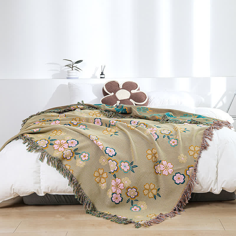 Weiche Decke mit Quasten und blühenden Blumen