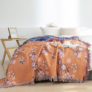 Weiche Decke mit Quasten und blühenden Blumen