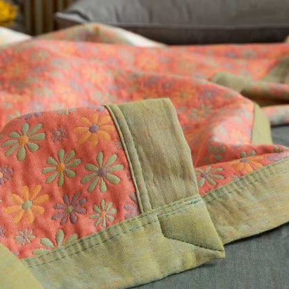 Wendbare Steppdecke aus Baumwolle mit buntem Gänseblümchenmuster