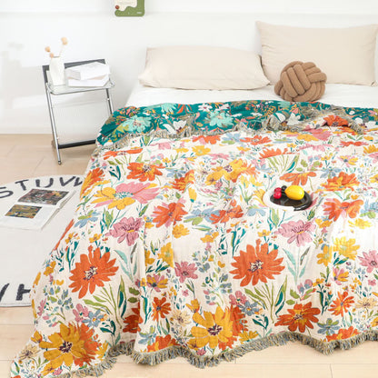 Wendbare Steppdecke aus Baumwollgaze mit leuchtendem Blumenmuster und Quasten