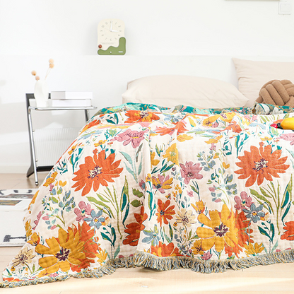 Wendbare Steppdecke aus Baumwollgaze mit leuchtendem Blumenmuster und Quasten