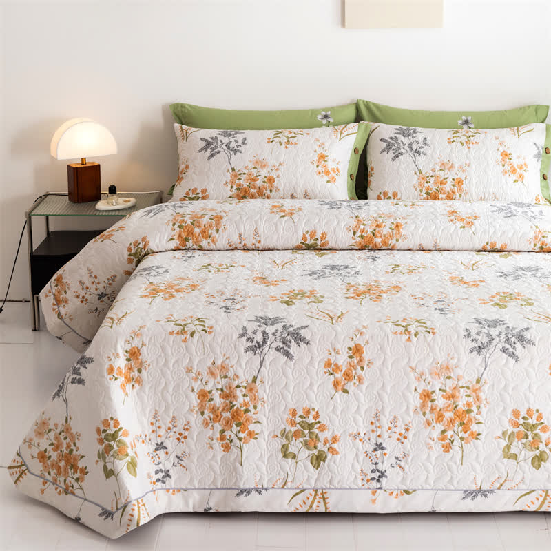 Orangefarbene Baumwollsteppdecke mit floralem Botanikdruck
