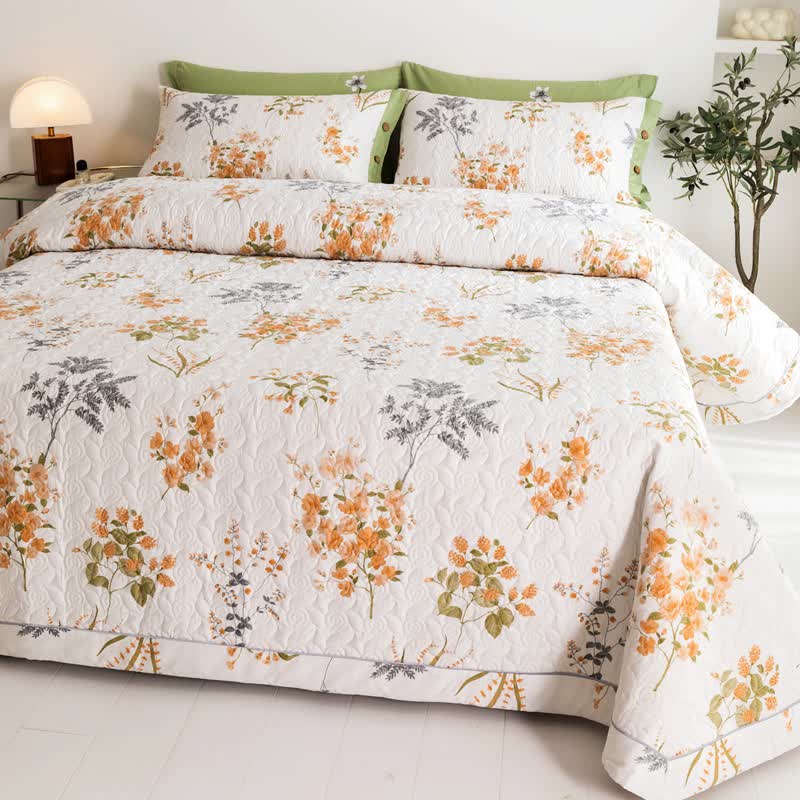 Orangefarbene Baumwollsteppdecke mit floralem Botanikdruck